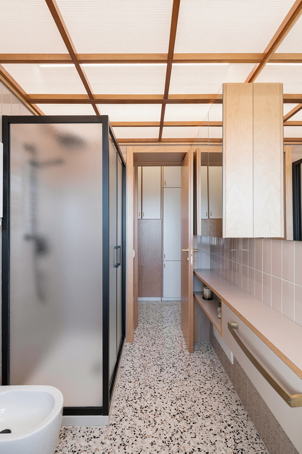 Contemporary bathroom with terrazzo flooring and wooden accents.