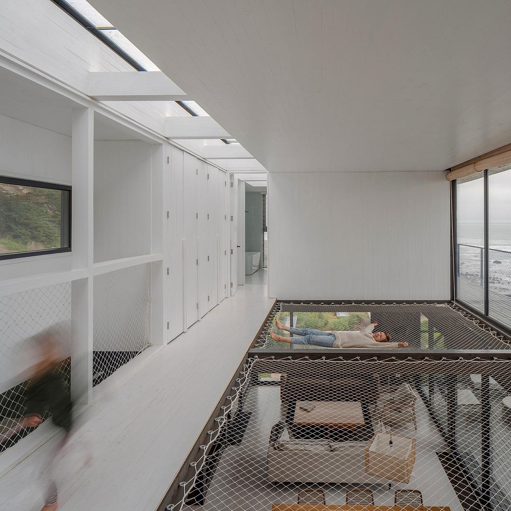 Minimalist interior with a netted lounge area and ocean view.