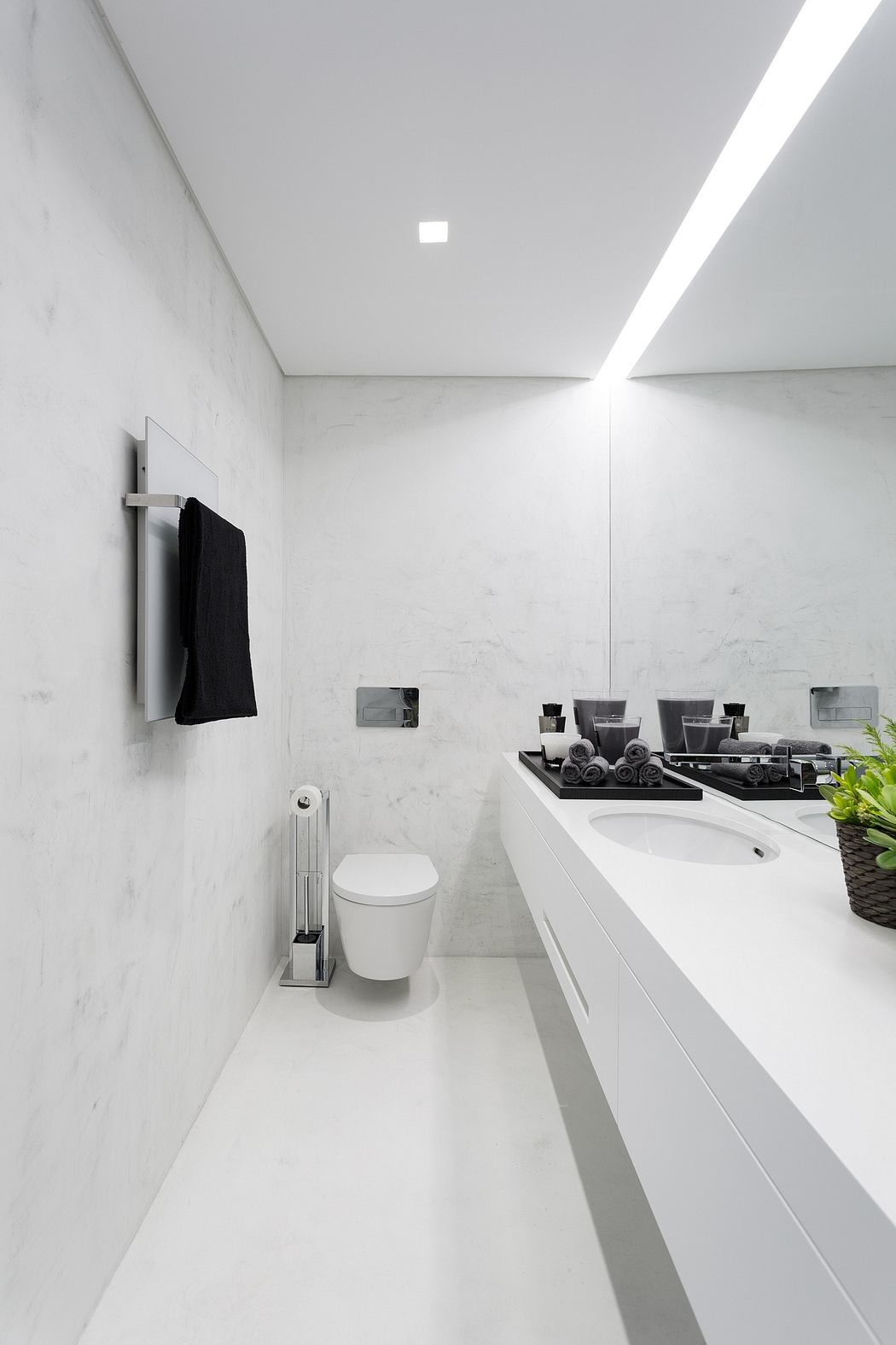 Modern bathroom with white marble walls and sleek fixtures.