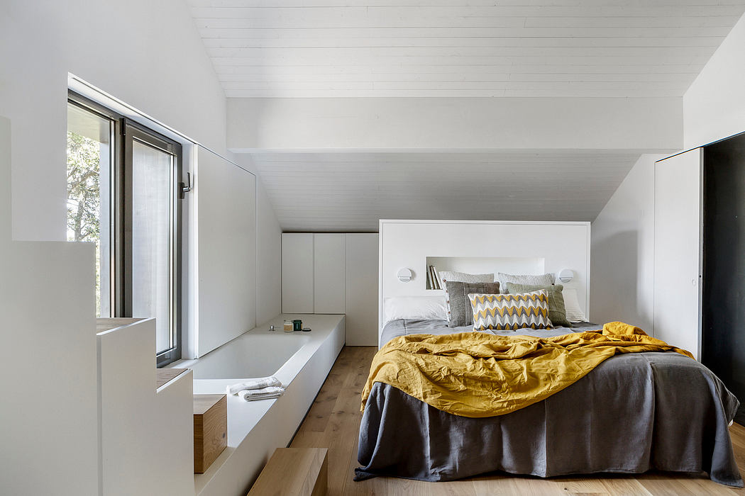 Minimalist bedroom with white walls and a yellow accent blanket.