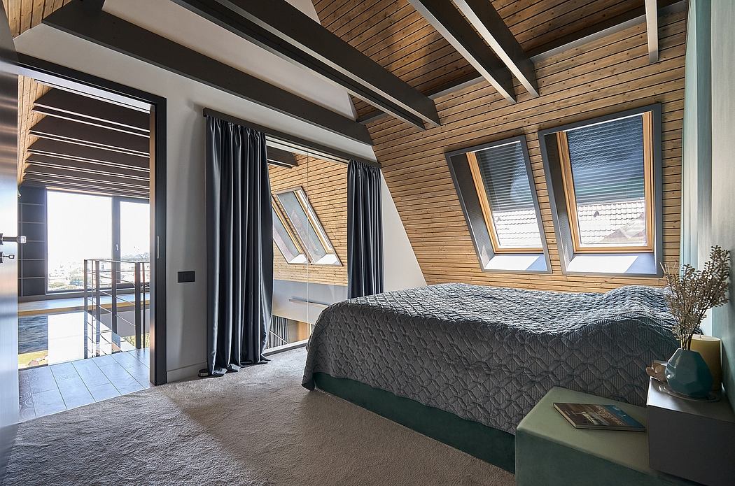 Modern attic bedroom with wooden beams, skylights, and balcony access.