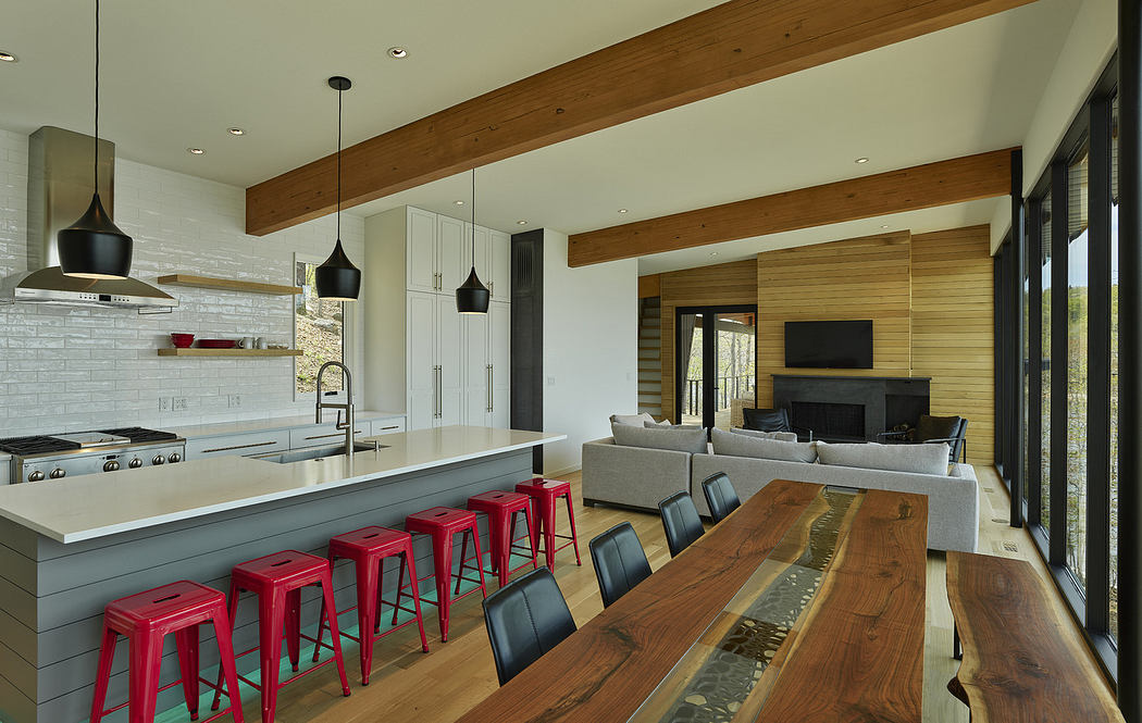 Contemporary kitchen with red stools, wooden accents, and pendant lights.