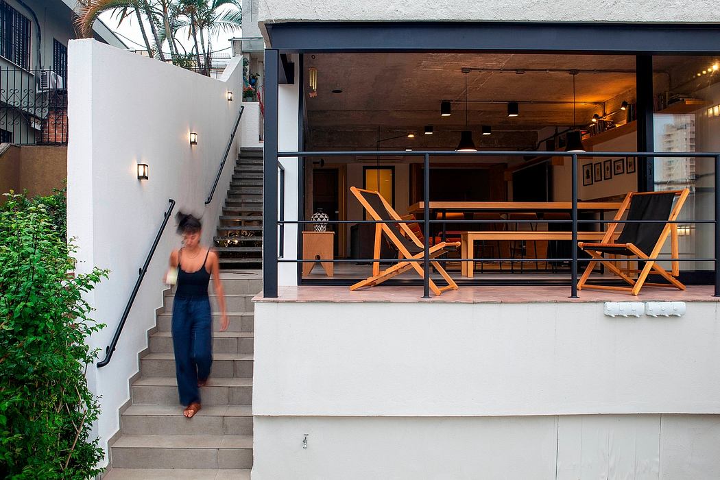 Chic patio with deck chairs, open living space, and staircase.
