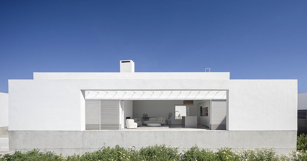 Minimalist white house with flat roof and large open patio.