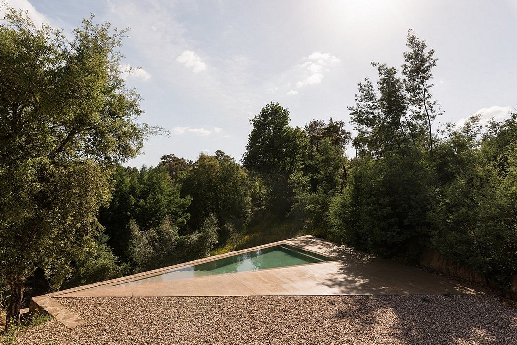 Sleek outdoor pool with geometric design, nestled in a natural landscape.
