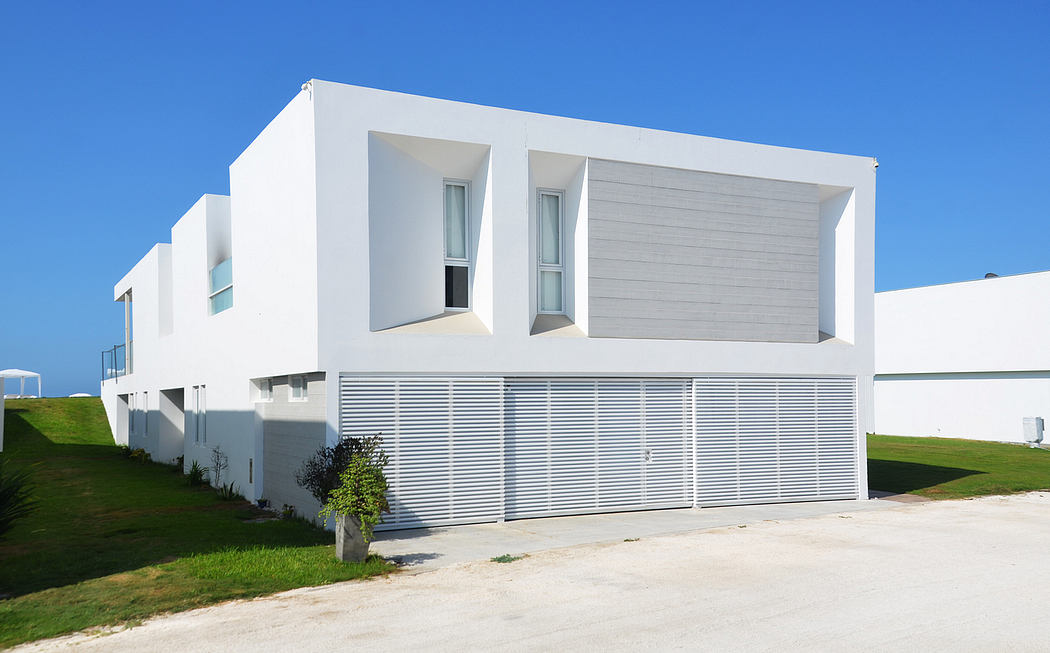 Modern white minimalist house with large garage door.