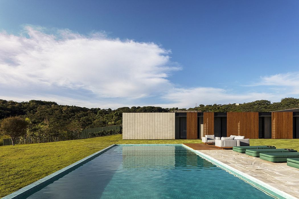 Contemporary home with pool, wood paneling, and minimalist outdoor furniture.