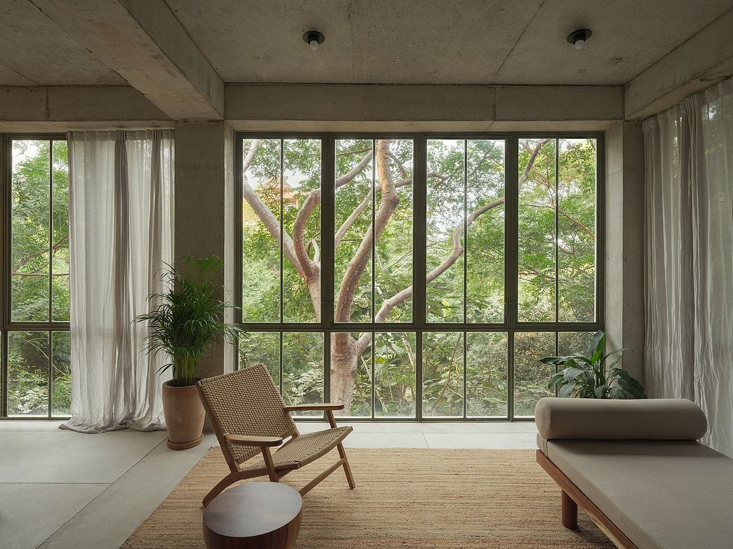 Minimalist room with large window overlooking trees.