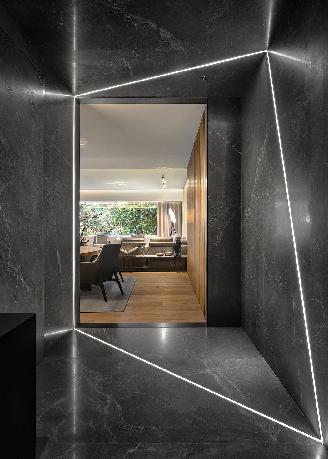 Sleek marble entryway with embedded LED lighting leading to a cozy, wood