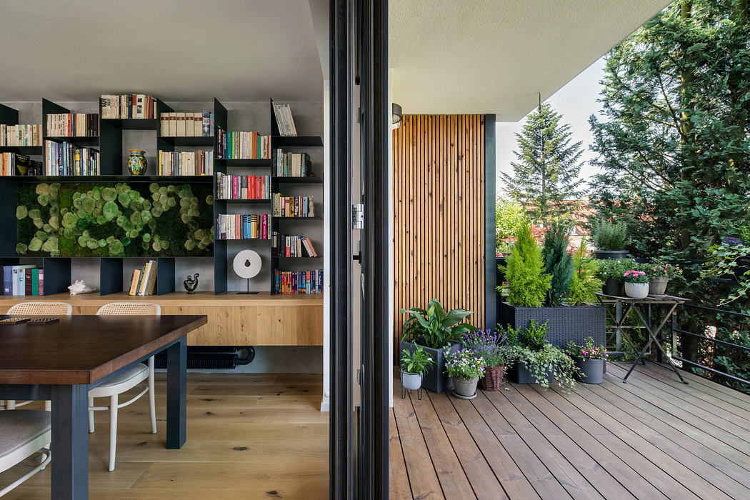 Sleek home office with bookshelf adjacent to cozy balcony with plants.