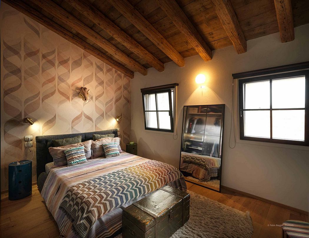 Cozy bedroom with geometric wallpaper, wooden beams, and rustic decor.