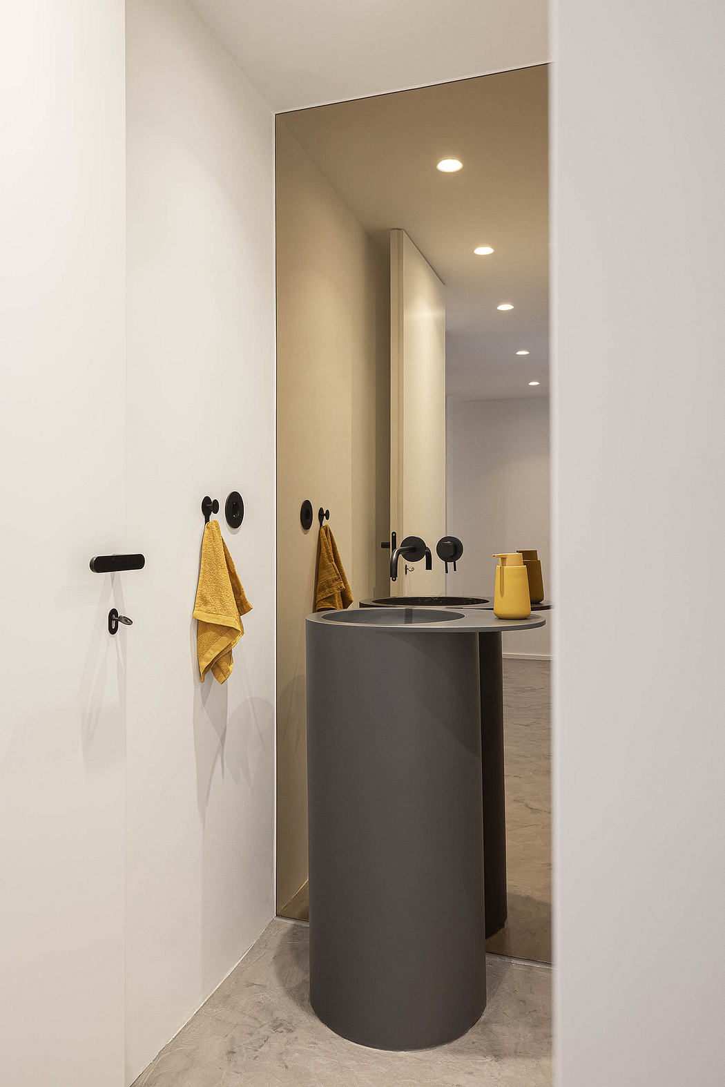 Contemporary bathroom with cylindrical sink and accent towels.