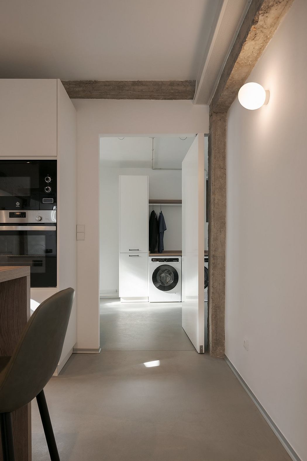 Contemporary hallway with exposed beams, minimalist decor, and integrated appliances.