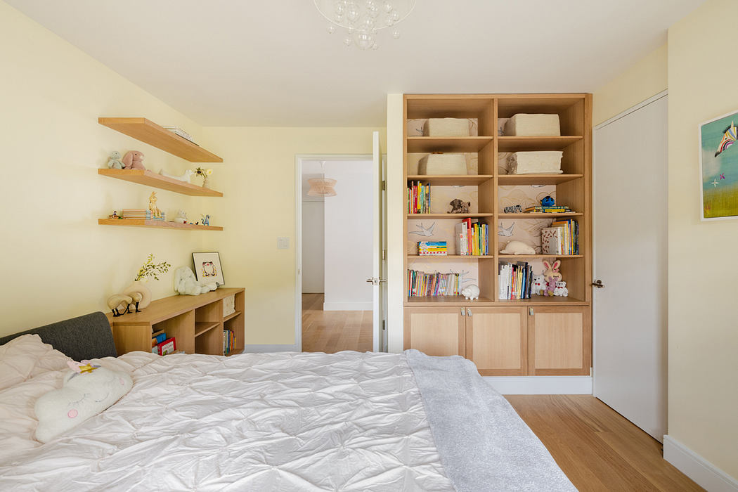 Bright bedroom with a large bed and built-in bookshelf.