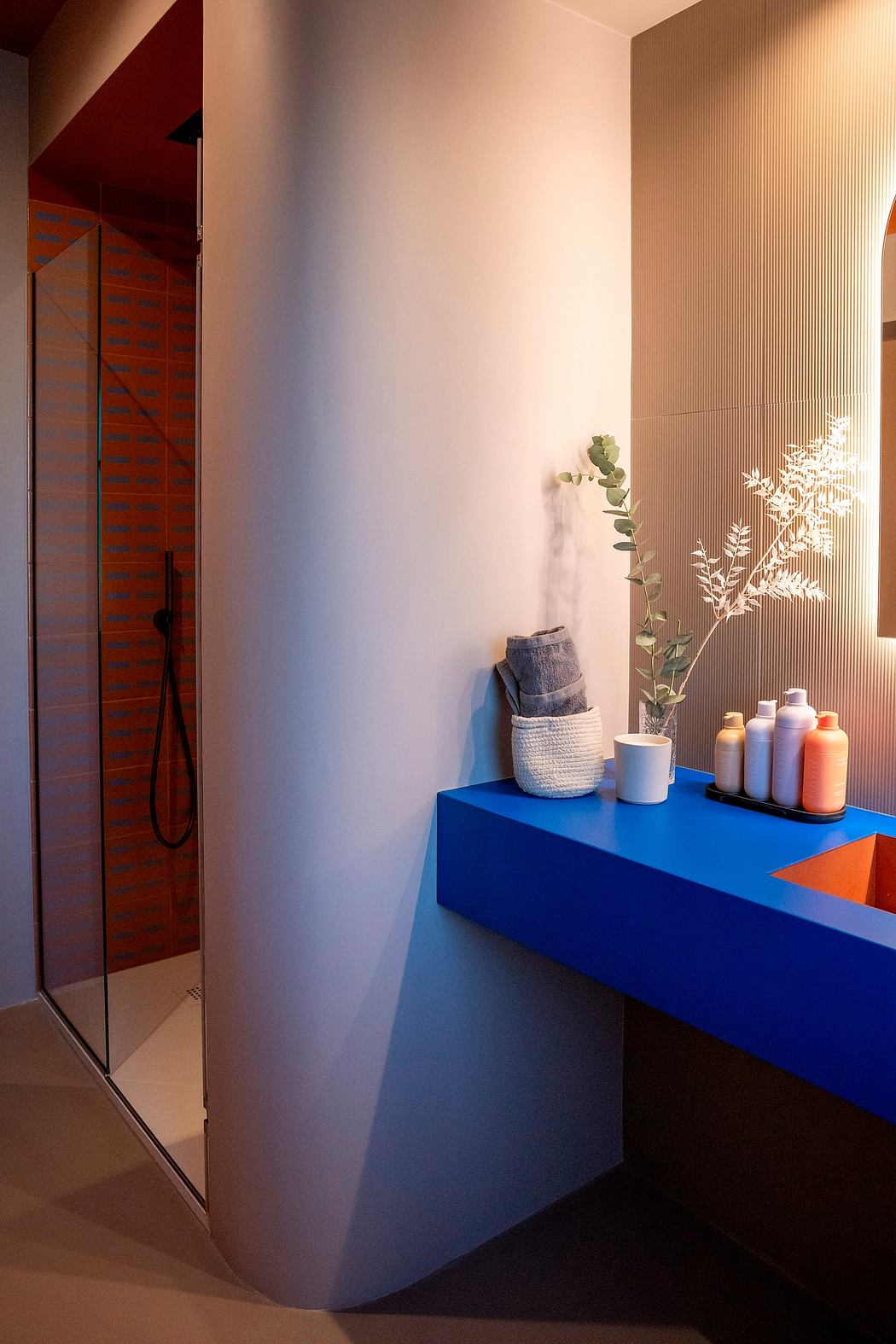Contemporary bathroom corner with blue shelf and shower.