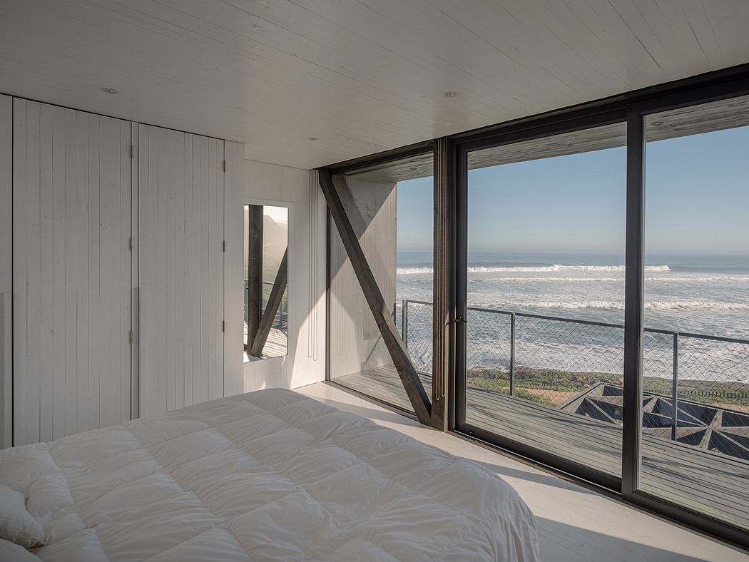 Modern bedroom with large windows overlooking the sea.