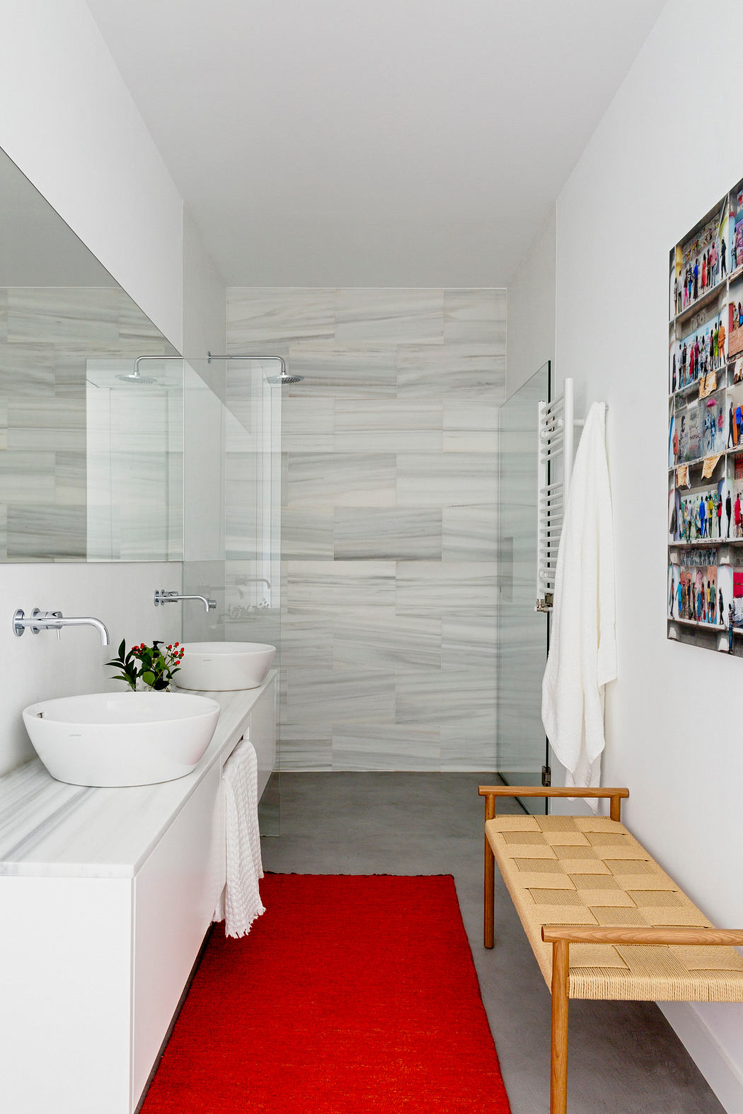Contemporary bathroom with white fixtures, red rug, and wooden bench.