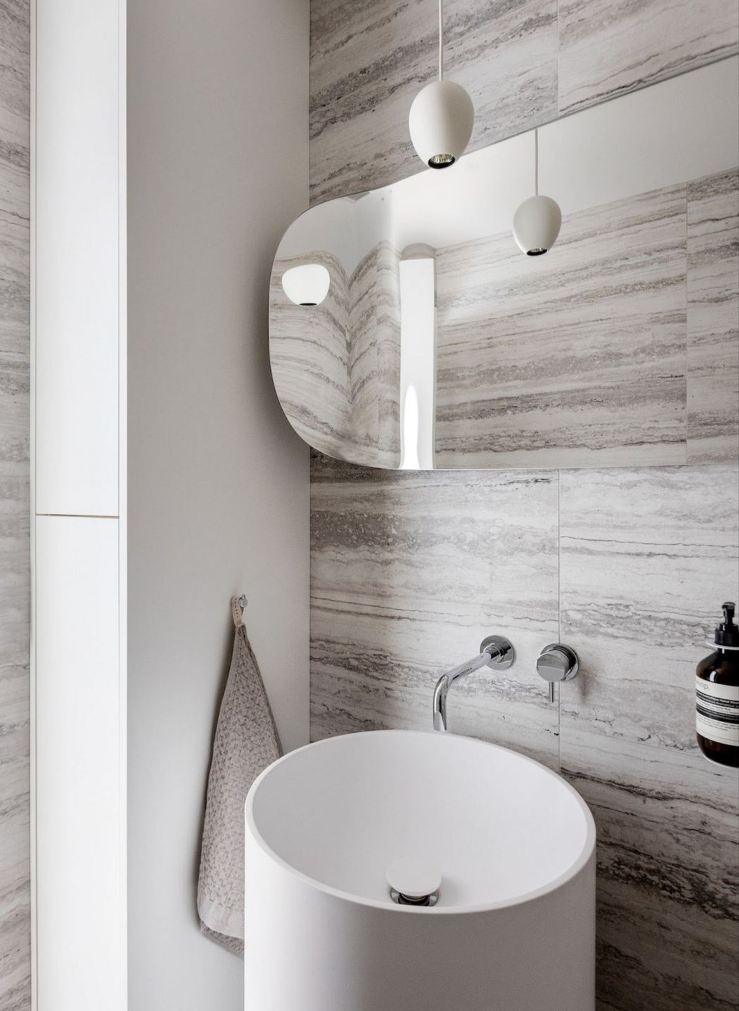 Contemporary bathroom with striped marble walls and round sink.