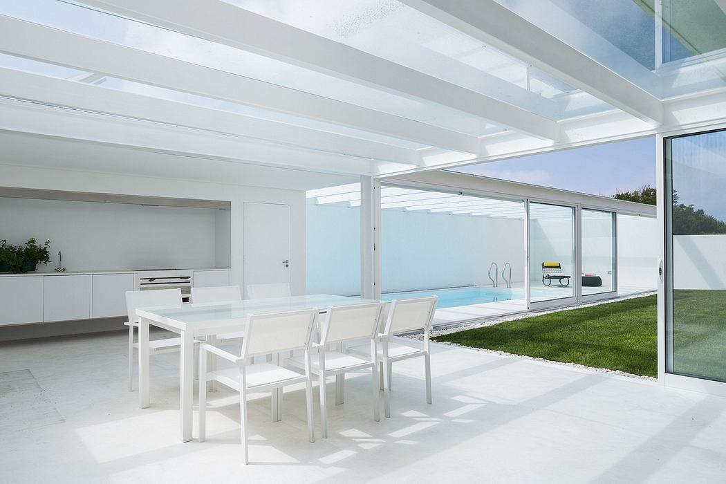 Minimalist dining area with large windows and skylight.