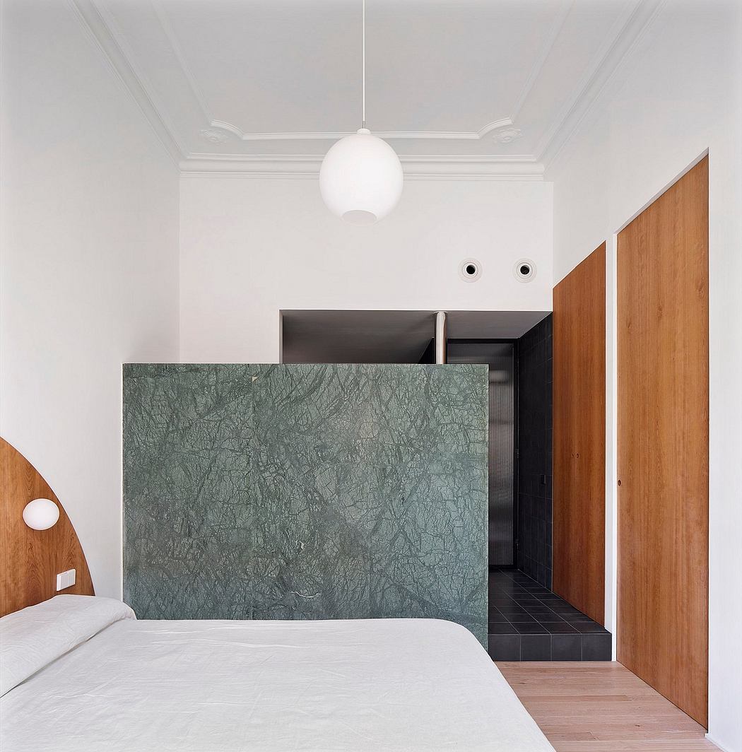 Modern bedroom with a green partition and wooden door.