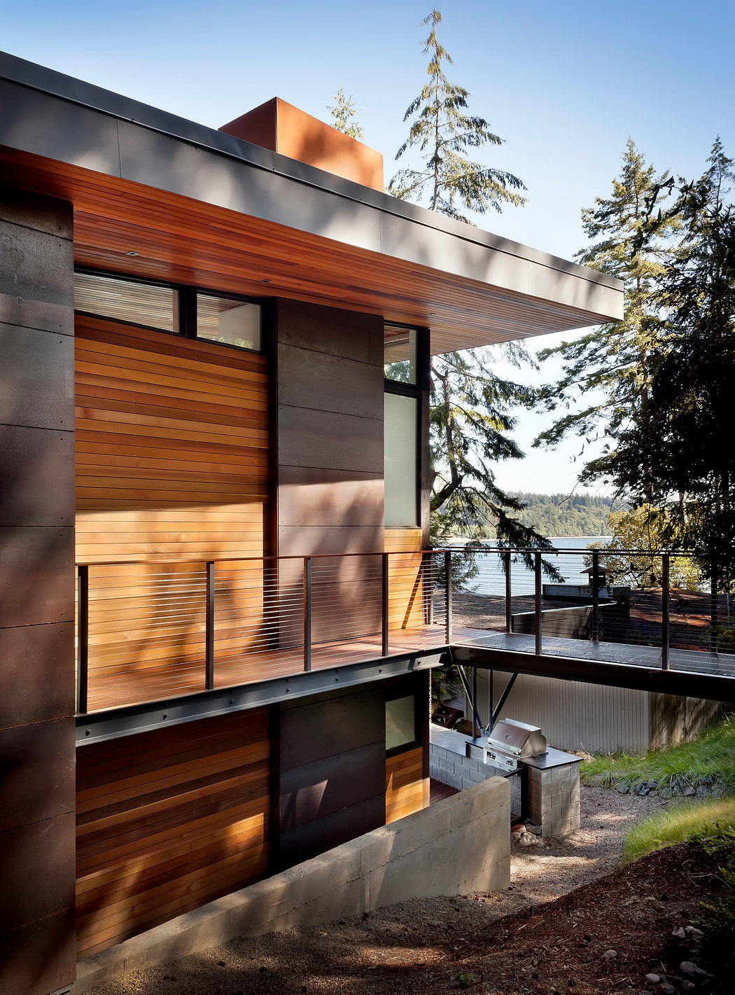 Contemporary house with wood paneling overlooking a lake.