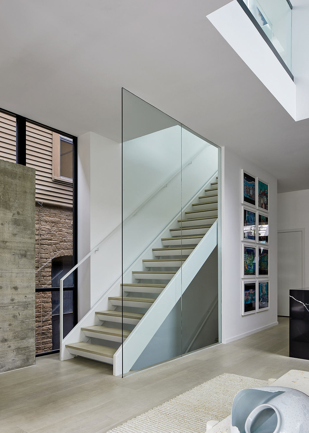 Sleek staircase with glass railing in a contemporary interior.