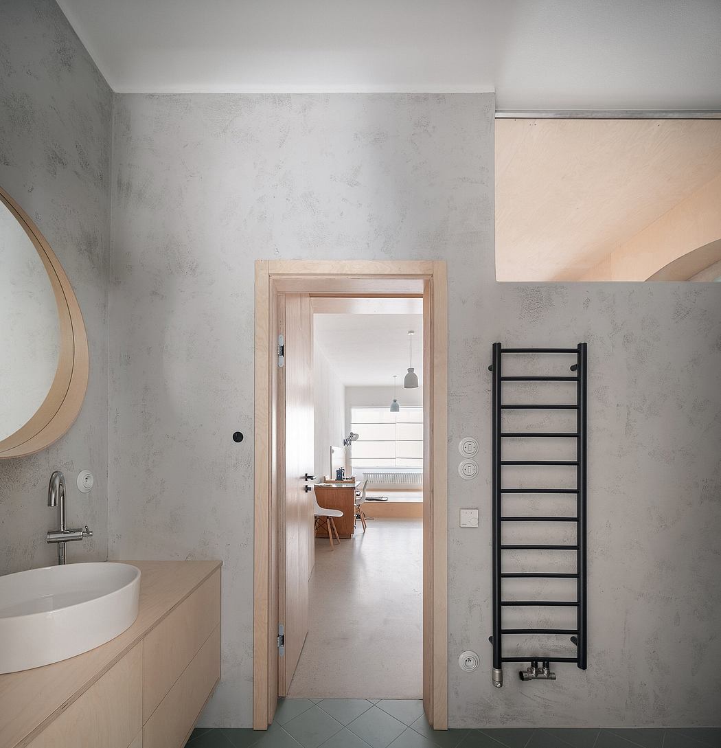 Minimalist bathroom with concrete walls, oval mirror, and a towel radiator.