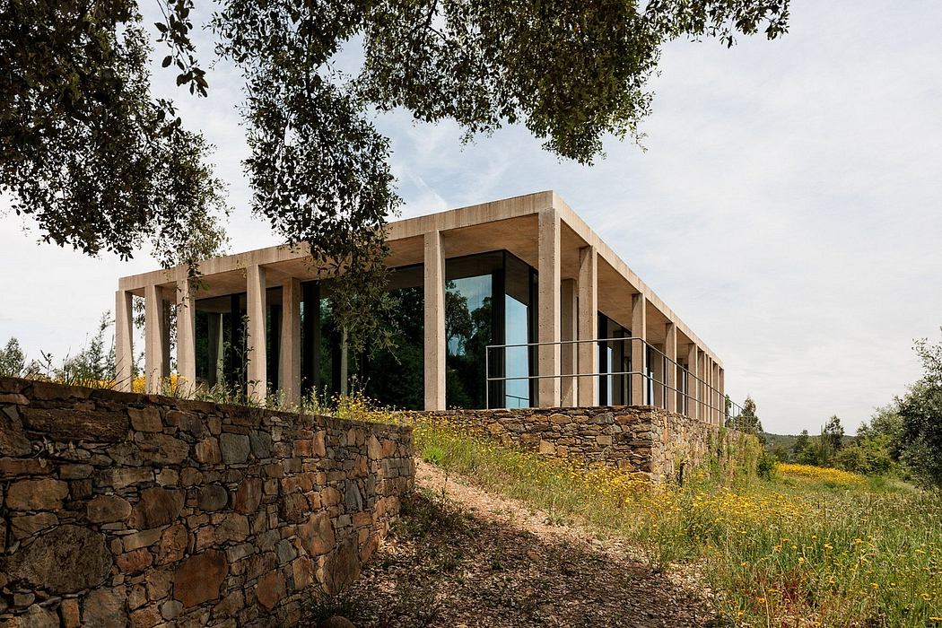 Contemporary glass building with stone foundation in natural landscape.