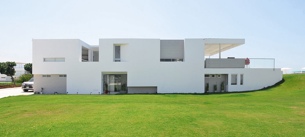 Contemporary white house with geometric design and large overhang.