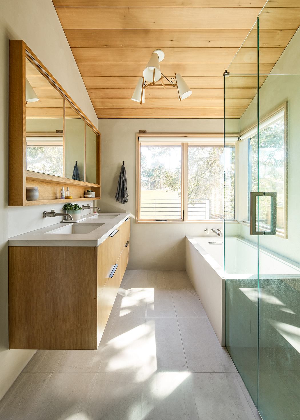 Modern bathroom with wood accents, large window, and glass shower.