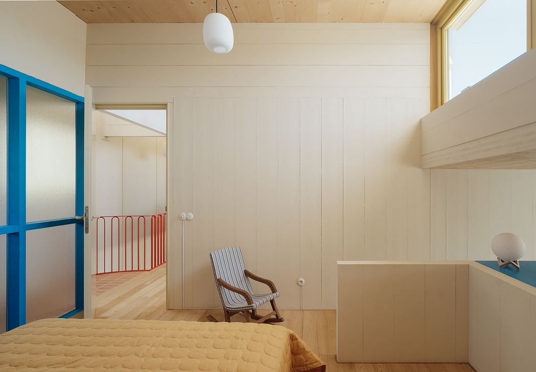 Minimalist bedroom with wooden ceiling, white walls, and blue door frame.
