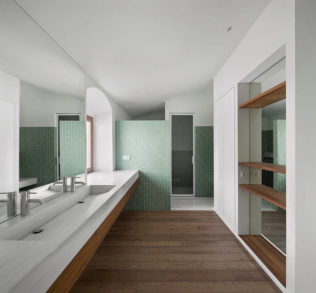 Minimalist bathroom with green tiles, wooden floor, and sleek fixtures.