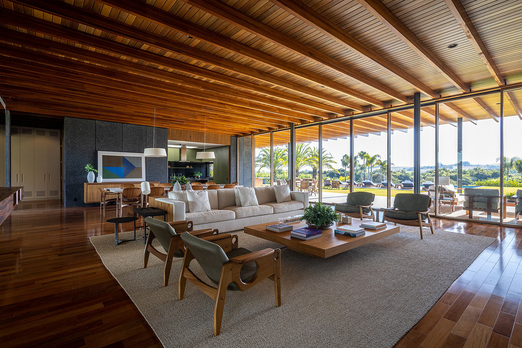 Modern living room with wooden floors, ceiling, and panoramic windows.
