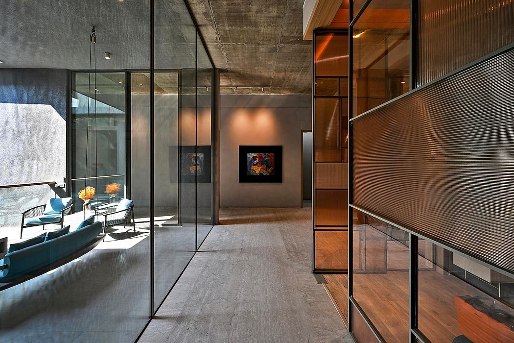 Modern interior with glass walls, minimalist furniture, and artwork.