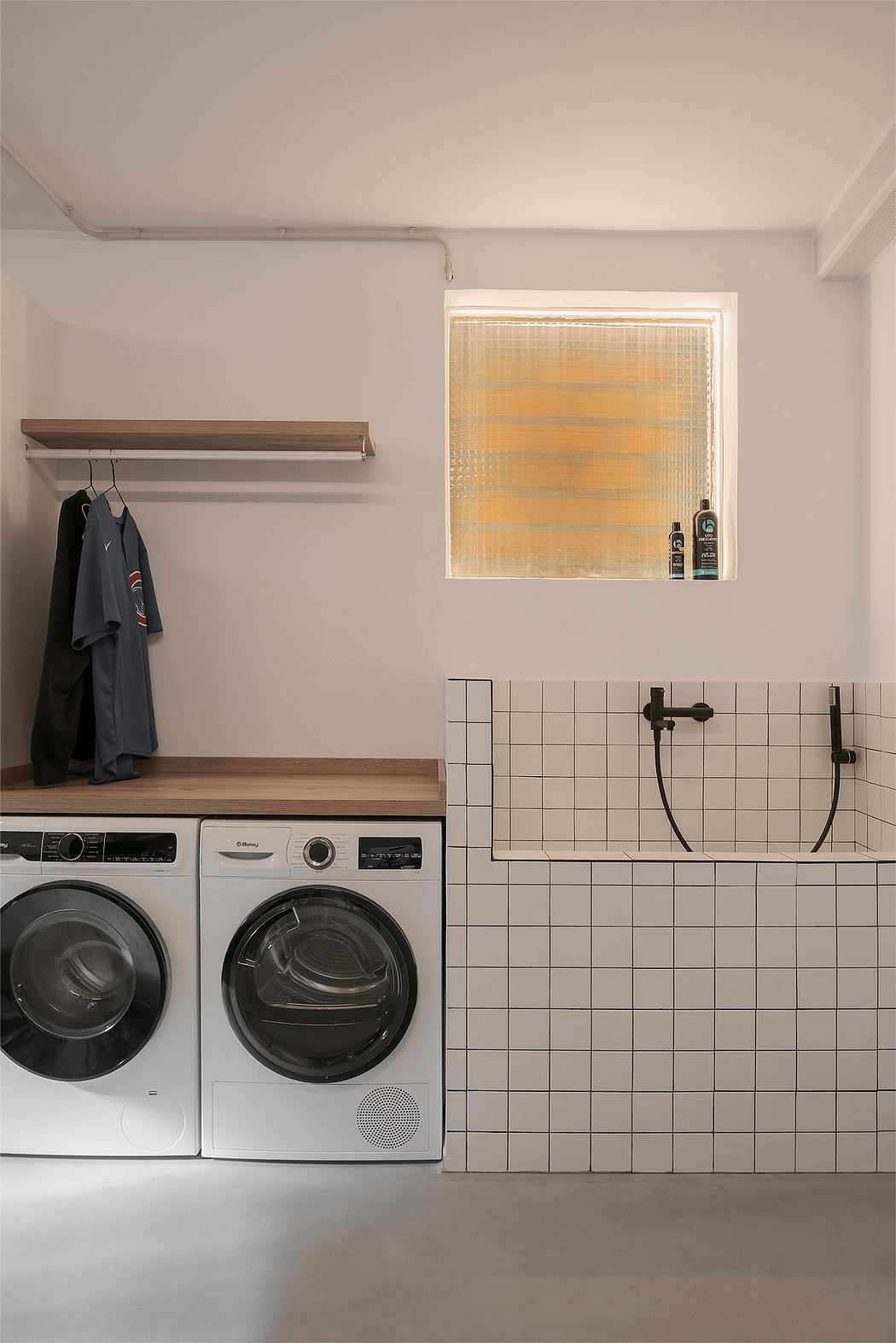 Minimalist laundry room with tiled sink and washer-dryer combo
