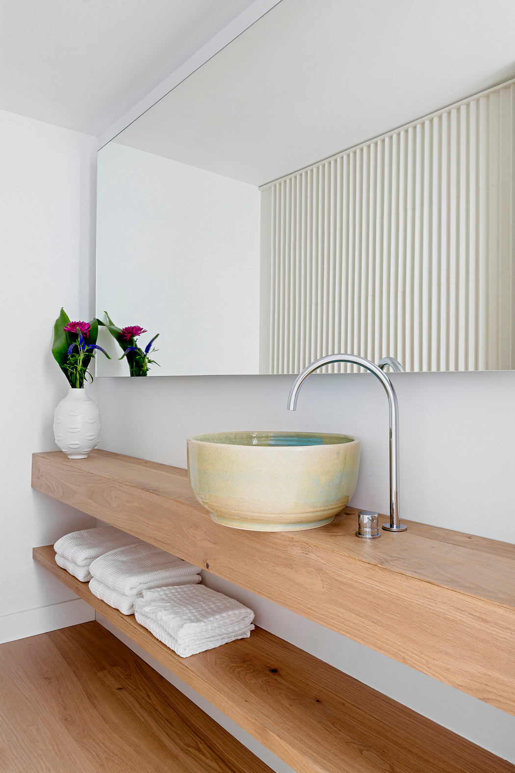 Modern bathroom with a wooden countertop, vessel sink, and chrome faucet.