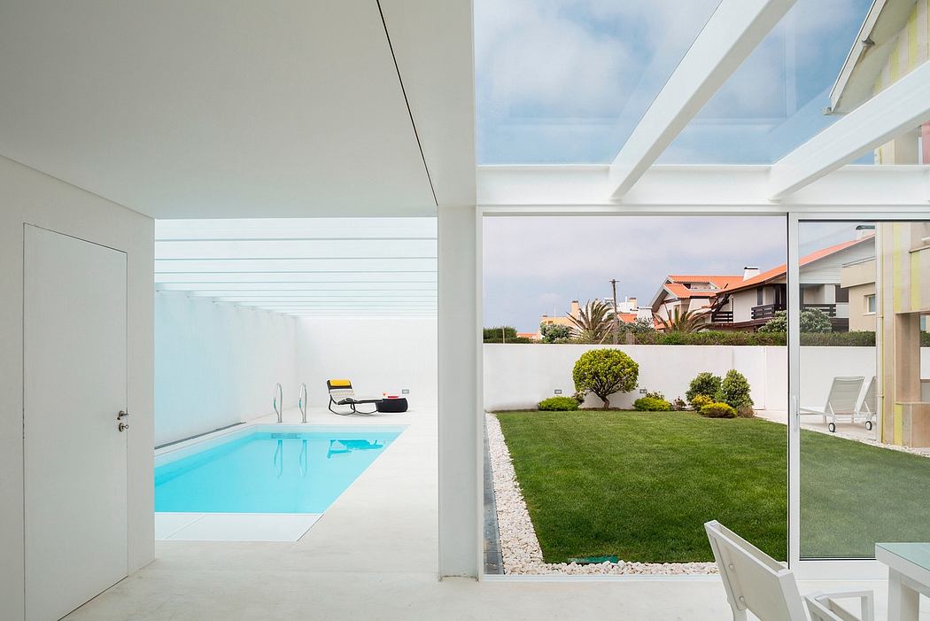 Modern home interior with view of pool and garden through large windows.