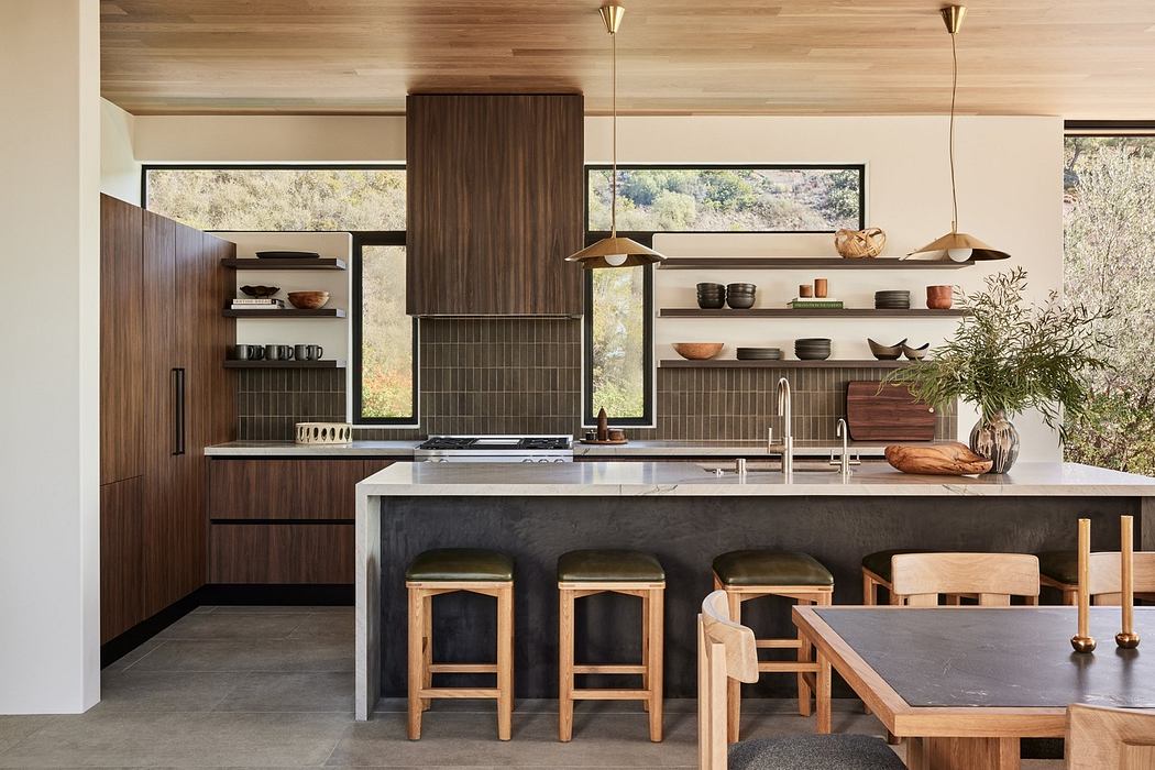 Modern kitchen with wooden cabinets, central island, and pendant lights.