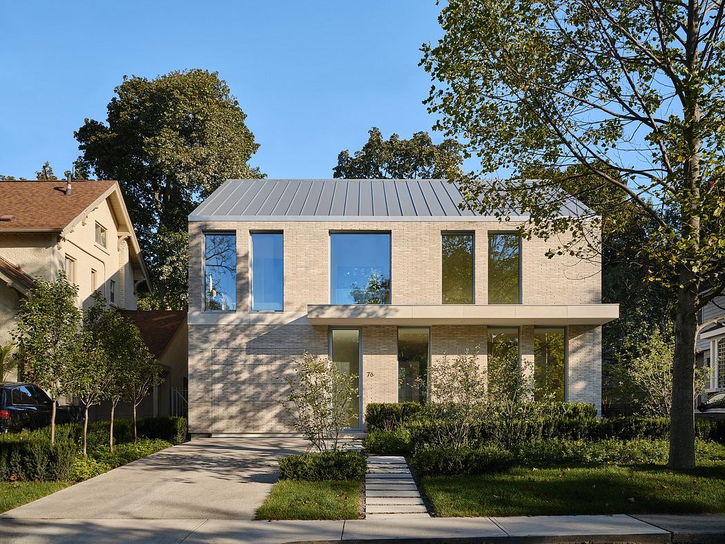 Modern two-story house with large windows and a metal roof.
