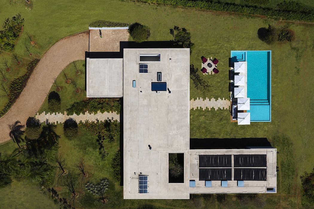 Aerial view of a modern house with a pool and solar panels.