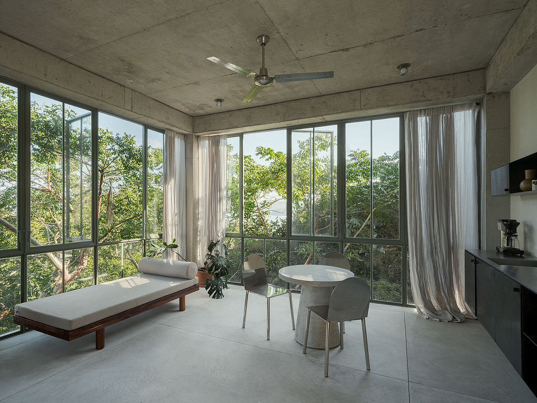 Modern room with large windows, concrete walls, and minimalistic furniture.