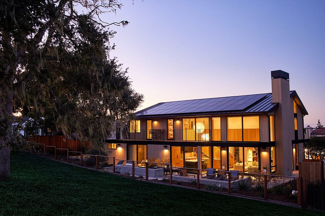 Contemporary two-story house with large windows at dusk.