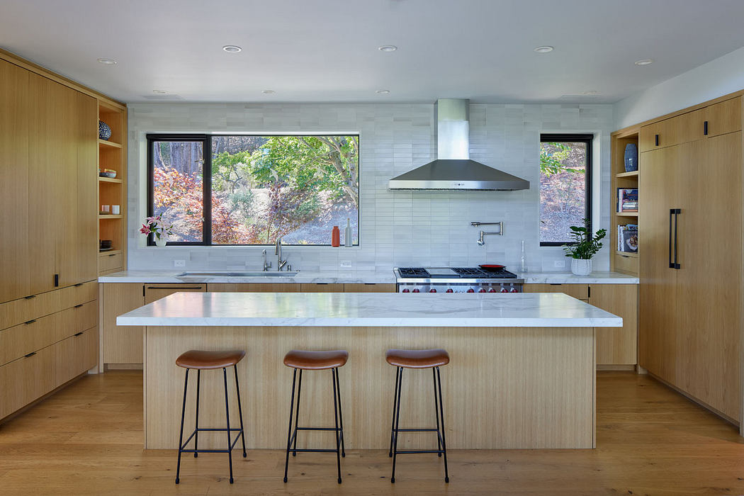 Modern kitchen with wooden cabinets, white countertops, and three bar stools.