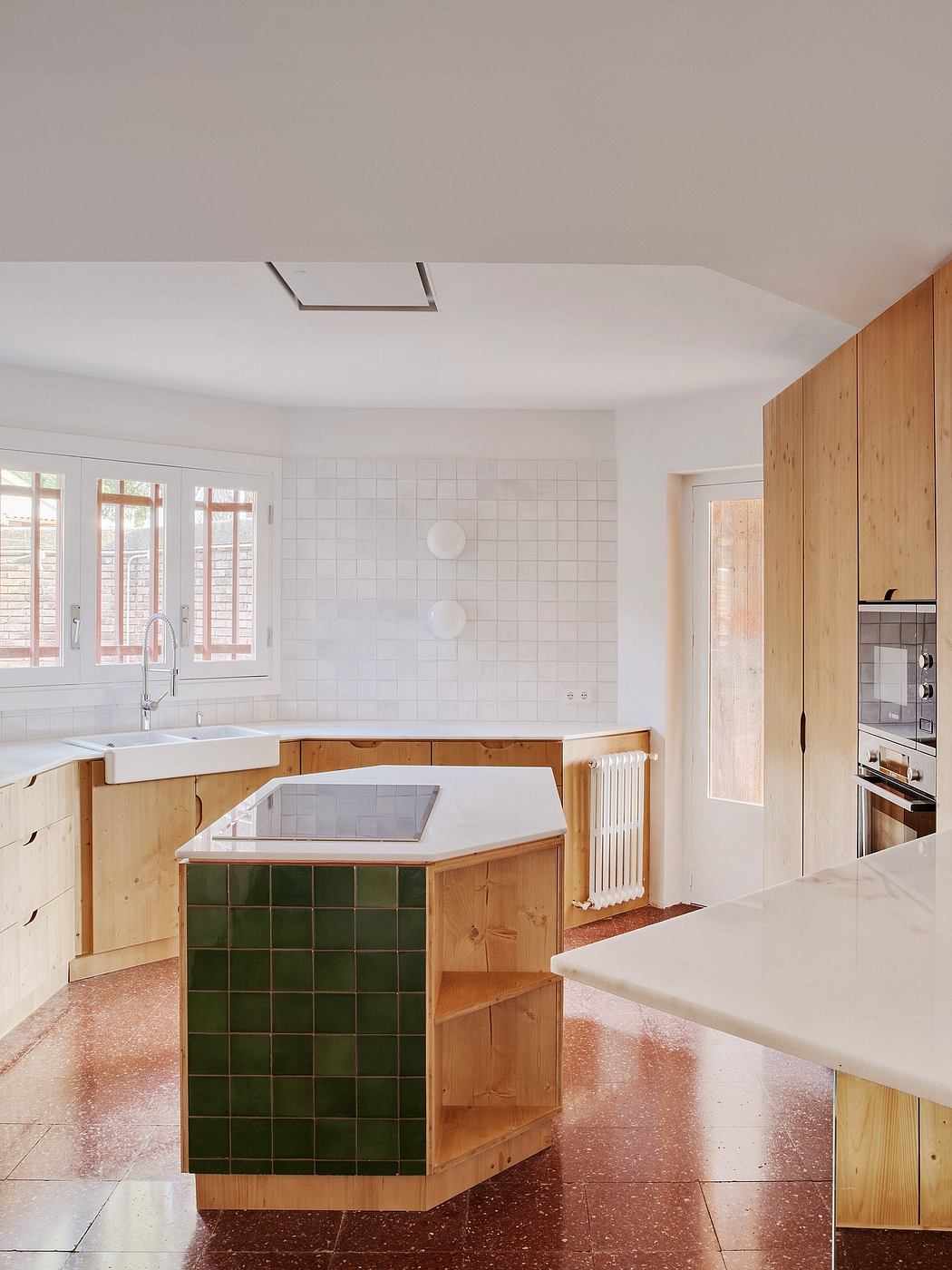 Modern kitchen with wooden cabinetry and terracotta tiled floor.