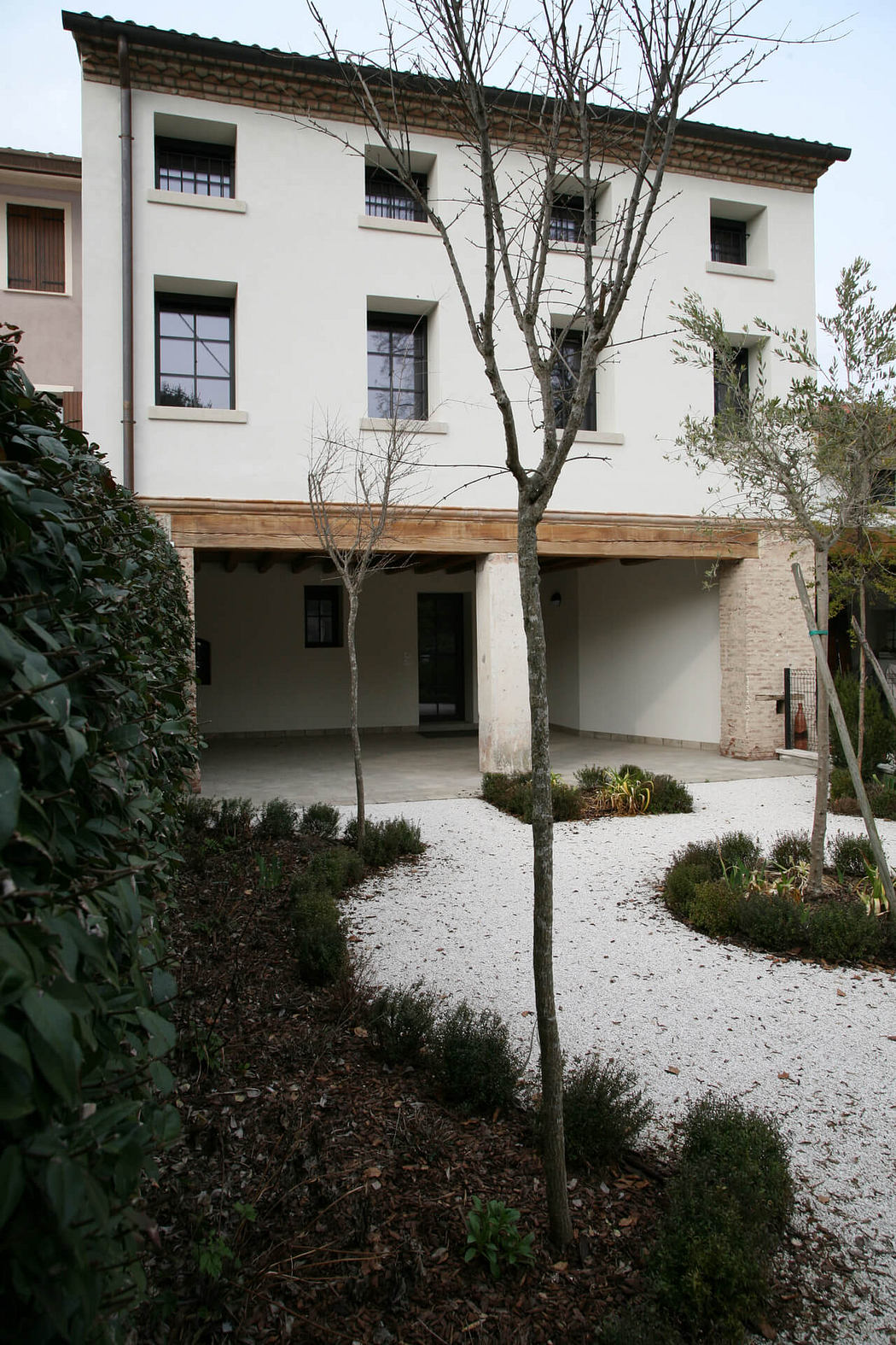 Two-story building with a covered patio and a pebbled garden path.