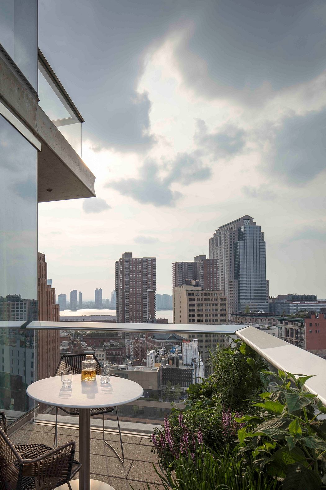 Balcony with city skyline view, table set for two.