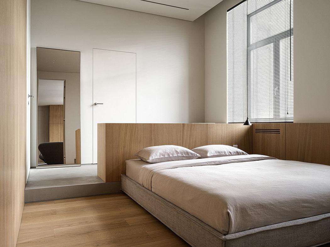 Minimalist bedroom with wooden features and neutral tones.