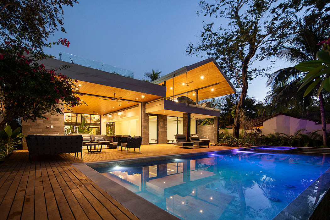 Modern house with illuminated interior and poolside at dusk.