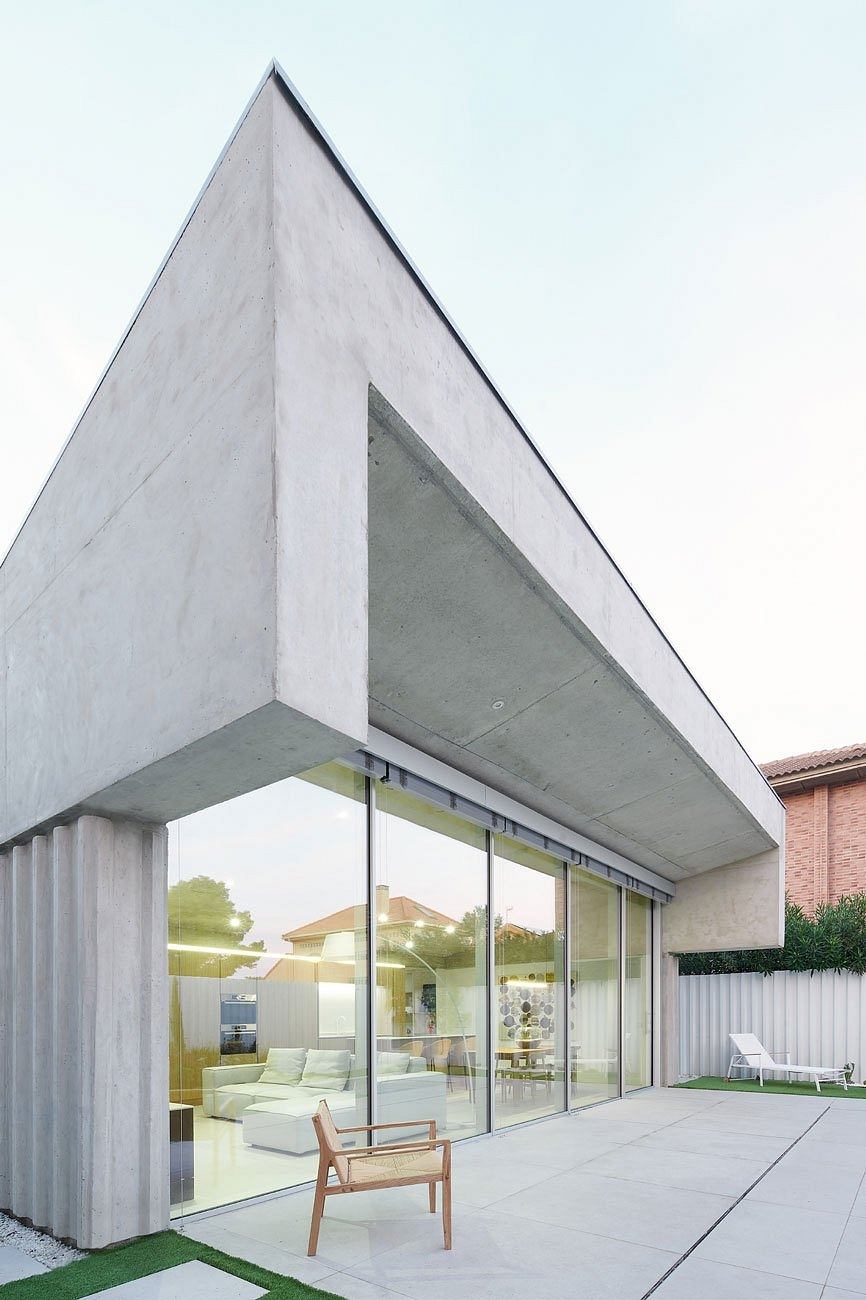 Modern house with a sharp triangular overhang and full-height glass walls.