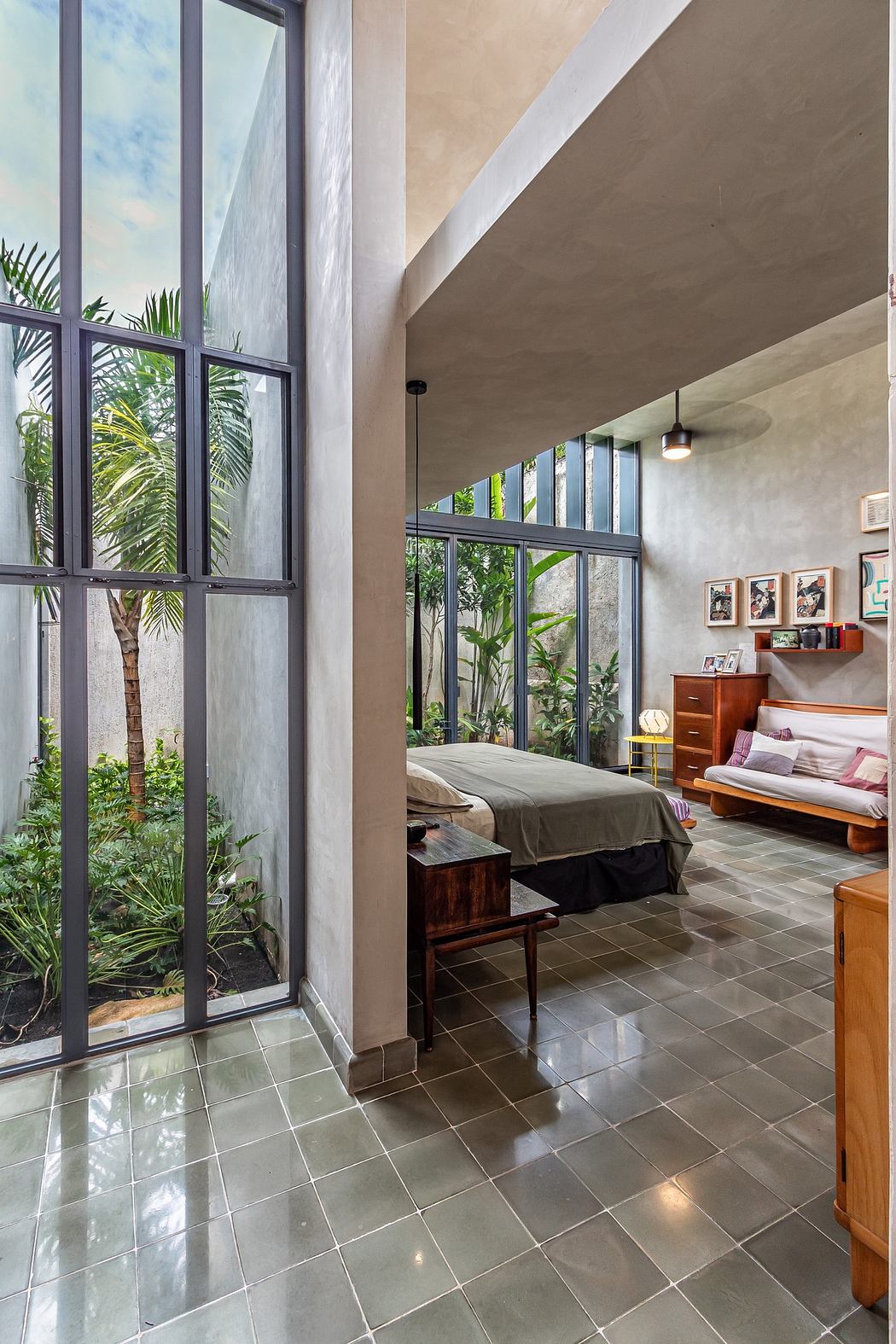 Modern bedroom with large windows overlooking a garden.